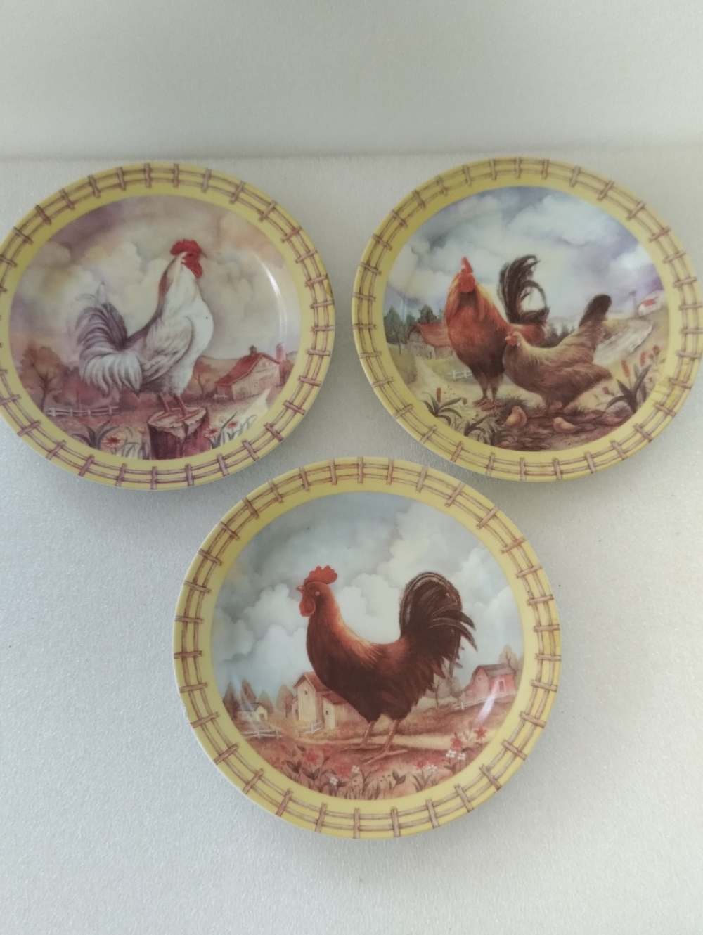 Rooster plates feature farmhouse scenes.  3 Pcs.